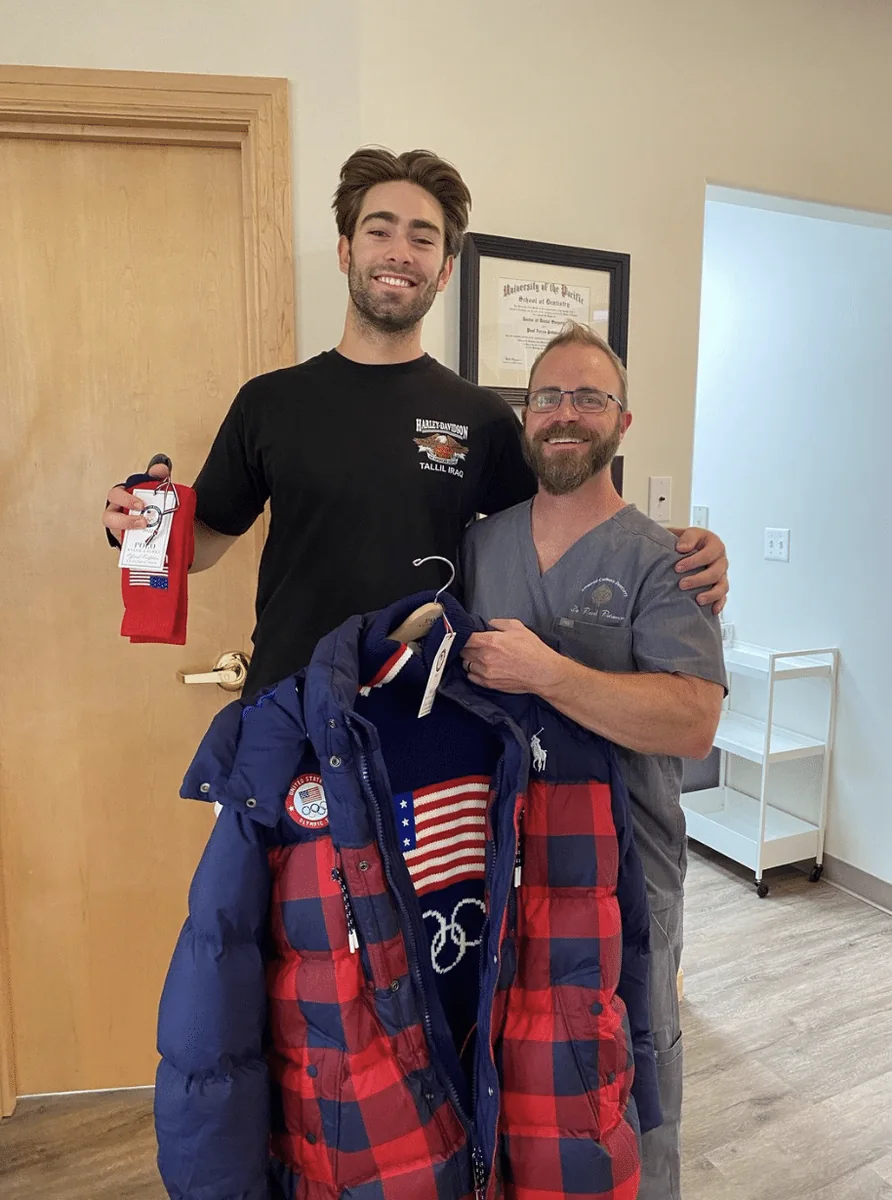 Alex Hall with Dr. Peterson holding U.S. Ski Team apparel